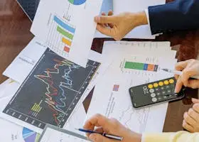 Business professionals analyzing financial charts and graphs during a meeting.
